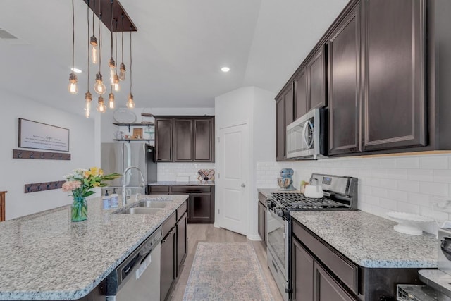 200 Waterway Ave, Hutto, TX 78634 - kitchen with appliances with stainless steel finishes, dark brown cabinetry, backsplash, a kitchen island with sink, and recessed lighting