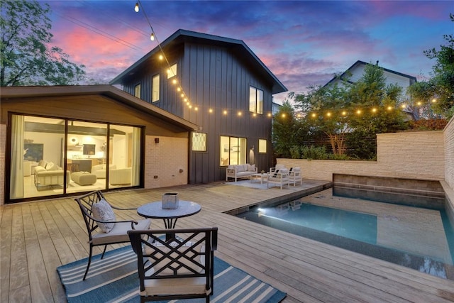 2901 S 5th St, Austin, TX 78704 - back of property at dusk with board and batten siding, outdoor lounge area, and a wooden deck