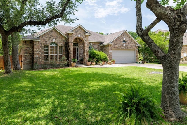 view of front facade featuring concrete driveway, a front yard, roof with shingles, brick siding, and a garage