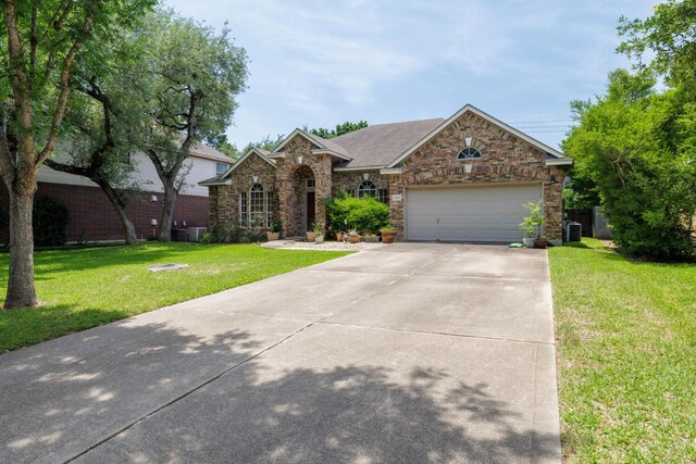 view of front of property featuring a front lawn, concrete driveway, a garage, central AC, and brick siding