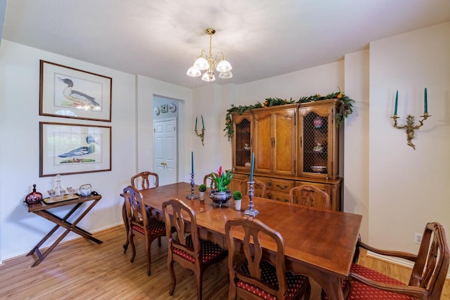 dining space with a chandelier, light wood-style floors, and baseboards