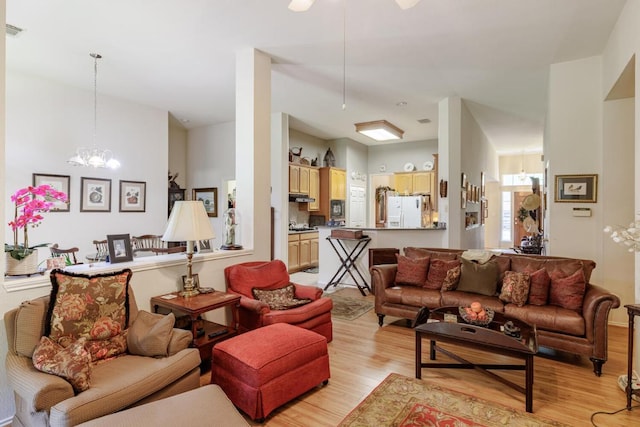 living area with light wood-style flooring and a chandelier