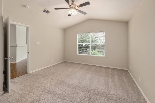 unfurnished room featuring carpet, a smoke detector, a ceiling fan, vaulted ceiling, and baseboards