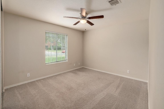 empty room with carpet flooring, ceiling fan, and baseboards