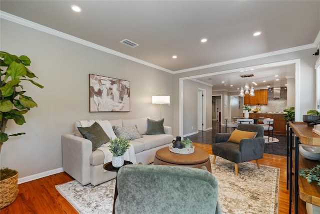 2601 W 49th St, Austin, TX 78731 - living room featuring baseboards, wood finished floors, recessed lighting, ornamental molding, and a chandelier