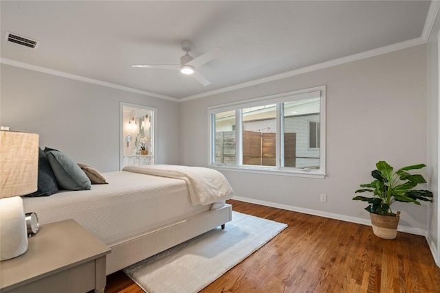 2601 W 49th St, Austin, TX 78731 - bedroom featuring baseboards, crown molding, wood finished floors, a ceiling fan, and ensuite bathroom
