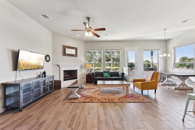 125 Redtail Ln, Leander, TX 78641 - living area with ceiling fan, wood finished floors, a fireplace with raised hearth, a chandelier, and recessed lighting