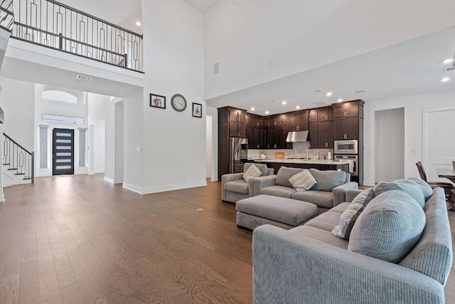 1616 Illawarra Way, Leander, TX 78641 - living area with dark wood-style flooring, stairway, baseboards, a towering ceiling, and recessed lighting