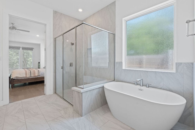 1616 Illawarra Way, Leander, TX 78641 - bathroom featuring ensuite bath, a shower stall, a soaking tub, ceiling fan, and tile walls