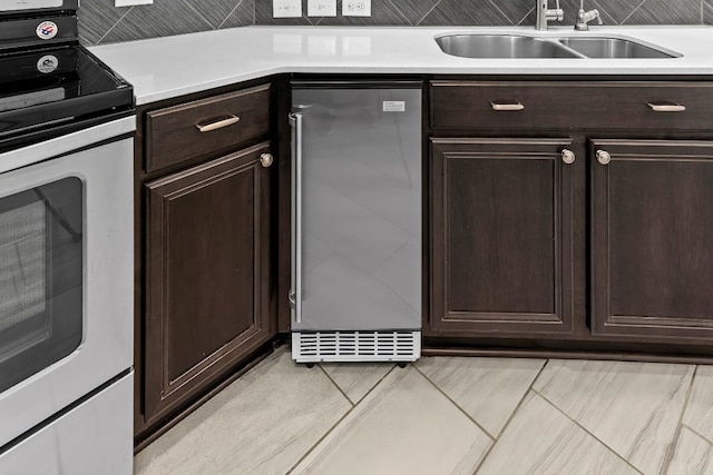 7604 Nunsland Dr, Austin, TX 78744 - kitchen with stainless steel electric range oven, a sink, refrigerator, dark brown cabinetry, and light countertops