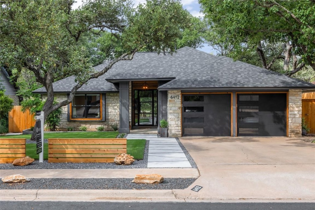 6412 Steer Trl, Austin, TX 78749 - view of front facade with stone siding, roof with shingles, driveway, and an attached garage