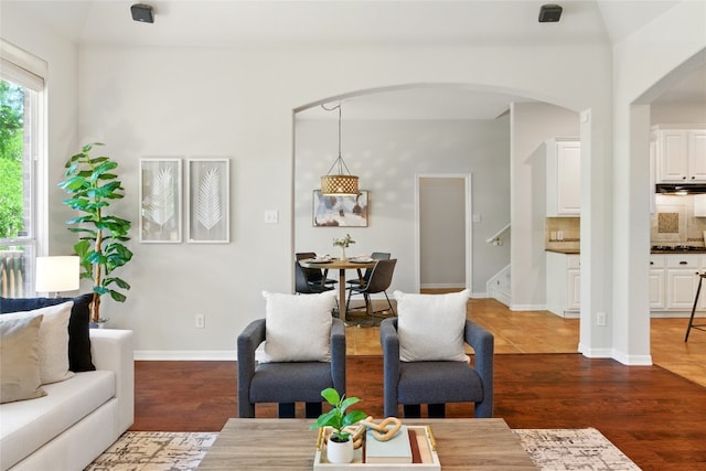 1607 Mesa Verde Dr, Round Rock, TX 78681 - living area featuring arched walkways, stairway, dark wood-type flooring, and baseboards