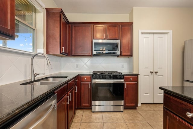 361 Stone View Trl, Austin, TX 78737 - kitchen with appliances with stainless steel finishes, a sink, reddish brown cabinets, backsplash, and dark stone counters