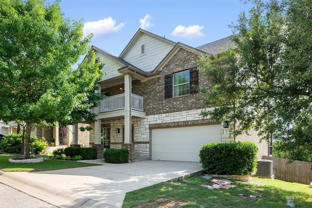 361 Stone View Trl, Austin, TX 78737 - view of front of house with stone siding, a balcony, concrete driveway, a garage, and central AC