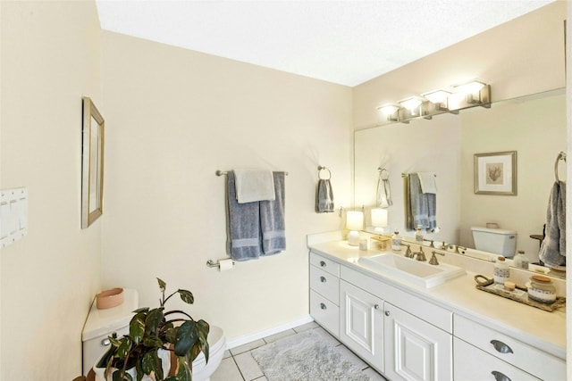 bathroom featuring tile patterned floors, vanity, toilet, and baseboards