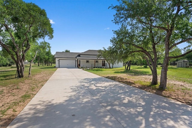 view of front of house featuring concrete driveway, a front yard, and an attached garage