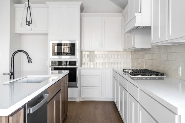 639 Bay Breeze Dr, Kyle, TX 78640 - kitchen with appliances with stainless steel finishes, a sink, backsplash, white cabinets, and lofted ceiling