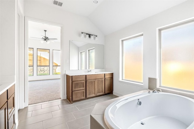 639 Bay Breeze Dr, Kyle, TX 78640 - bathroom featuring vaulted ceiling, a garden tub, vanity, ceiling fan, and tile patterned floors