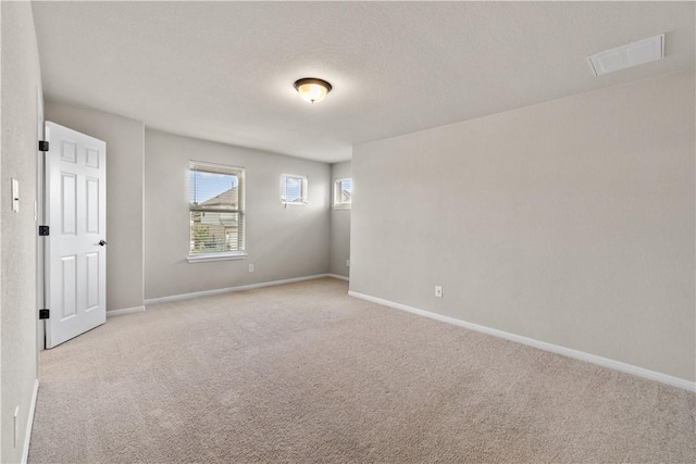 unfurnished room with light carpet and baseboards