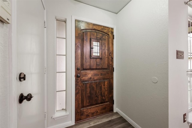 entrance foyer with dark wood finished floors and baseboards