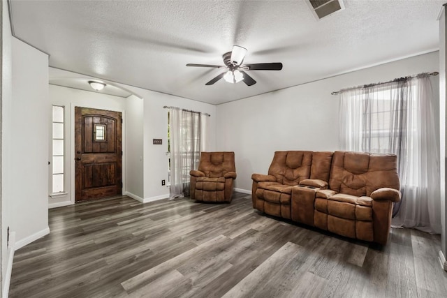 living room with ceiling fan, wood finished floors, a textured ceiling, and baseboards