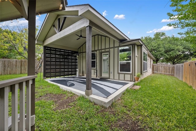rear view of property with board and batten siding, a ceiling fan, and a patio