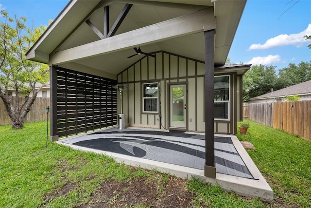 back of house with board and batten siding, ceiling fan, and a patio area