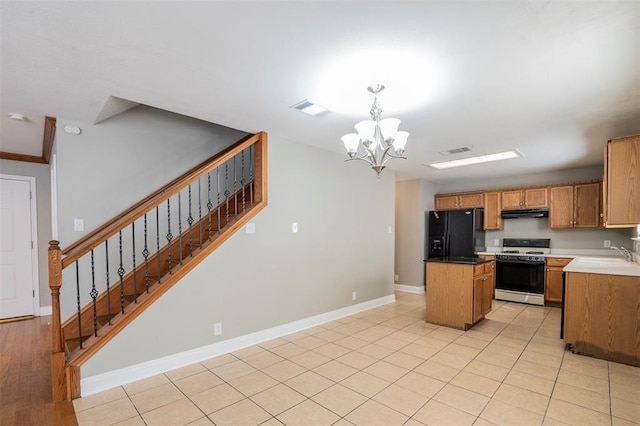 1802 Vanderhill Cv, Cedar Park, TX 78613 - kitchen featuring gas range gas stove, black fridge, a kitchen island, a chandelier, and baseboards