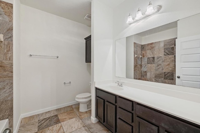 503 S Meadowlark St Unit B, Lakeway, TX 78734 - bathroom with toilet, vanity, baseboards, and a tile shower