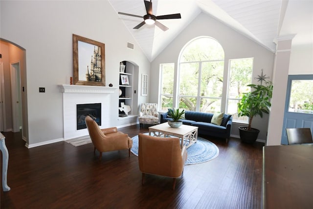 1401 Brixey Cv, Austin, TX 78754 - living area featuring ceiling fan, built in shelves, high vaulted ceiling, a glass covered fireplace, and arched walkways