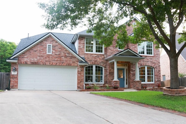 1401 Brixey Cv, Austin, TX 78754 - view of front facade with driveway, a garage, brick siding, and roof with shingles