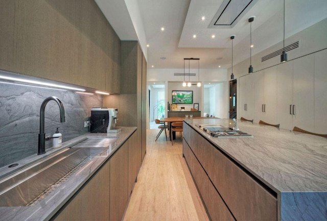 2309 S 4th St, Austin, TX 78704 - kitchen with modern cabinets, a sink, light wood-style flooring, tasteful backsplash, and recessed lighting