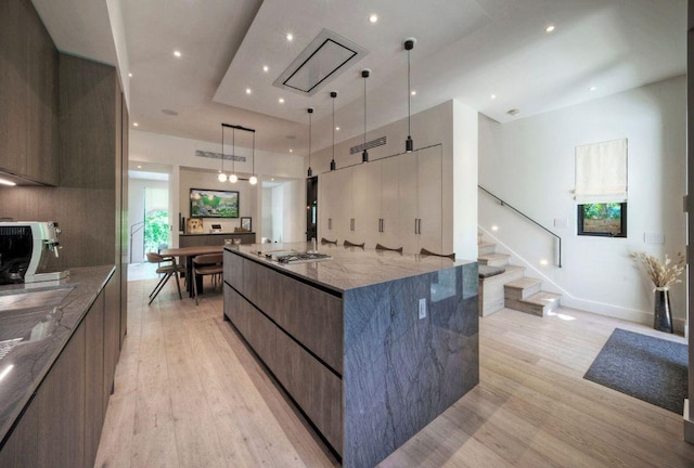 2309 S 4th St, Austin, TX 78704 - kitchen featuring modern cabinets, light wood-style floors, a spacious island, stone countertops, and recessed lighting