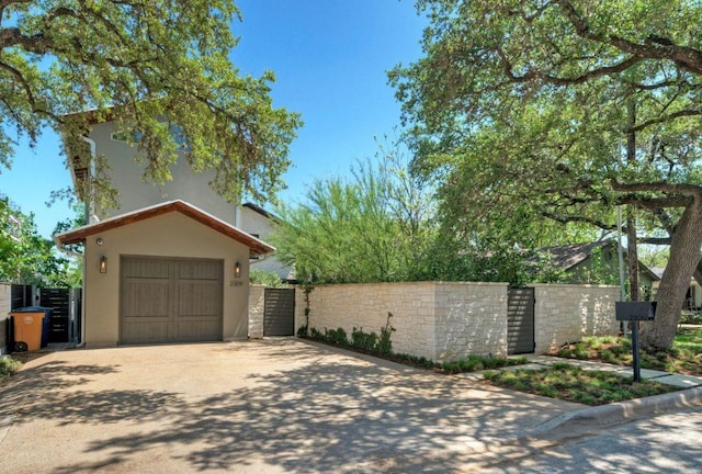 2309 S 4th St, Austin, TX 78704 - view of front of house featuring driveway, stucco siding, a garage, a gate, and fence