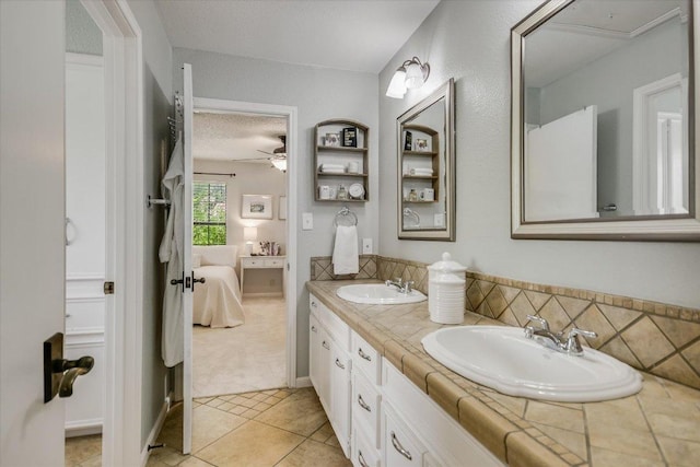 3301 Arrowhead Cir, Round Rock, TX 78681 - full bath featuring ensuite bath, double vanity, tile patterned flooring, ceiling fan, and a textured ceiling