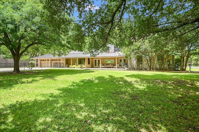 3301 Arrowhead Cir, Round Rock, TX 78681 - back of house featuring a garage, a standing seam roof, french doors, and a metal roof