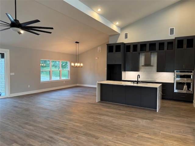 3318 Bay W Blvd, Horseshoe Bay, TX 78657 - kitchen with wall chimney exhaust hood, dark cabinetry, stainless steel double oven, light countertops, and open floor plan