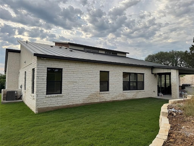 3318 Bay W Blvd, Horseshoe Bay, TX 78657 - back of property with a lawn, cooling unit, a standing seam roof, and metal roof