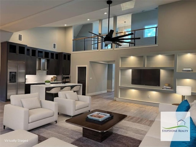 3318 Bay W Blvd, Horseshoe Bay, TX 78657 - living area featuring a chandelier, a towering ceiling, light wood-style floors, and recessed lighting