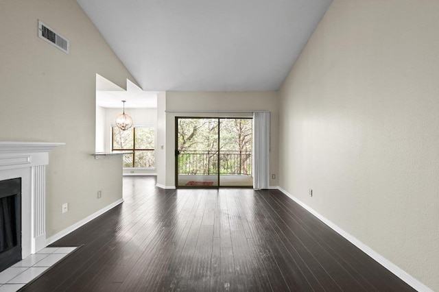 6000 Shepherd Mountain Cv Unit 107, Austin, TX 78730 - unfurnished living room featuring vaulted ceiling, a fireplace with flush hearth, hardwood / wood-style flooring, baseboards, and a chandelier