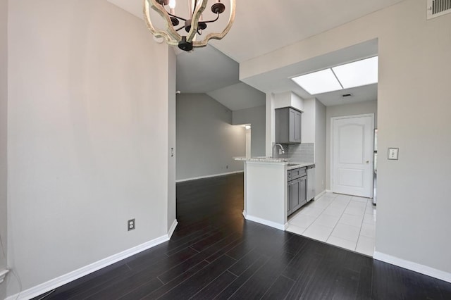 6000 Shepherd Mountain Cv Unit 107, Austin, TX 78730 - kitchen featuring gray cabinetry, a chandelier, light wood-type flooring, dishwasher, and baseboards