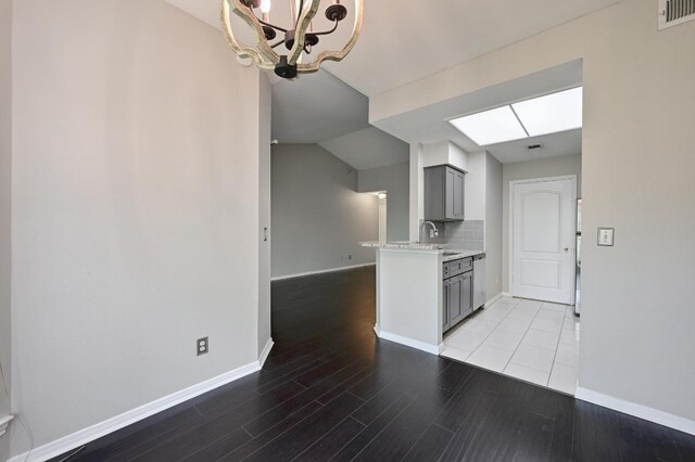 6000 Shepherd Mountain Cv Unit 107, Austin, TX 78730 - kitchen featuring gray cabinets, a chandelier, light wood-style flooring, dishwasher, and backsplash