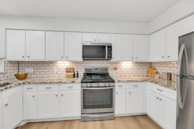 5901 Jacob Gln, Austin, TX 78727 - kitchen featuring stainless steel appliances, light wood finished floors, and white cabinetry
