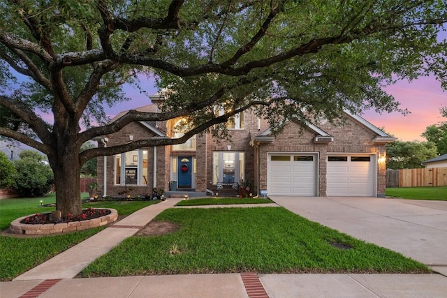 traditional home with brick siding, concrete driveway, and a garage