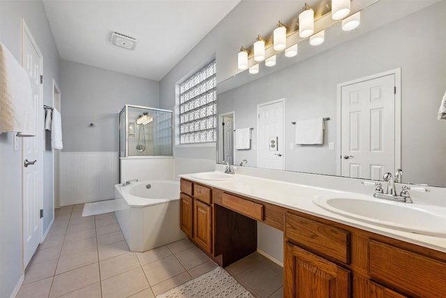 full bathroom featuring a stall shower, a garden tub, double vanity, and tile patterned flooring