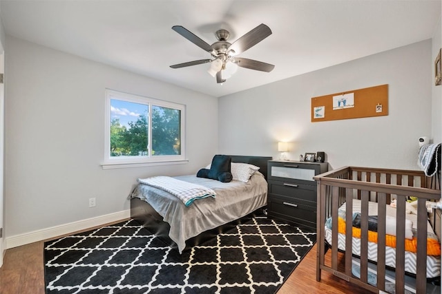 bedroom with baseboards, wood finished floors, and a ceiling fan