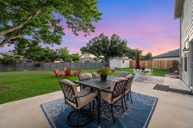view of patio featuring outdoor dining area, a storage shed, and an outdoor structure