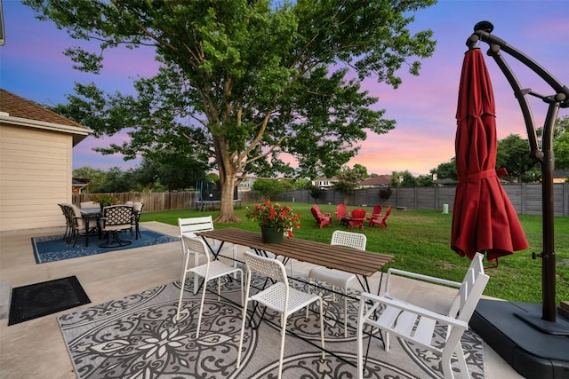 patio terrace at dusk with outdoor dining area and a trampoline