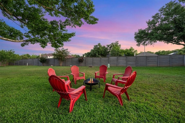 yard at dusk featuring an outdoor fire pit