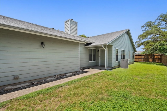 back of property with central air condition unit and a chimney